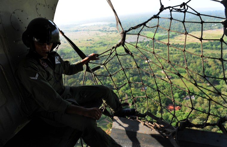 A Sri Lankan soldier sits in a helicopter transporting journalists to the northeast of Sri Lanka on April 24, 2009.  The Sri Lankan army has made steady advances in recent months against the separatist Liberation Tigers of Tamil Eelam (LTTE), slowly beating back the guerrillas. The army said the guerrillas controlled a mere 10-12 square kilometres of territory on the northeast coast, where thousands of civilians are still trapped by the fighting.    AFP PHOTO/PEDRO UGARTE (Photo credit should read PEDRO UGARTE/AFP/Getty Images)