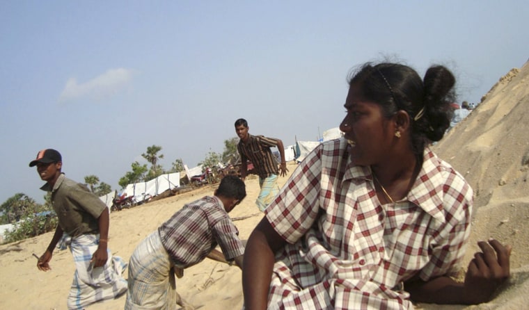 Sri Lankan ethnic Tamil civilians trapped in Tiger-controlled war zone take cover from shell firing in Mullivaikal, Sri Lanka, Monday, May 4, 2009. (AP Photo)