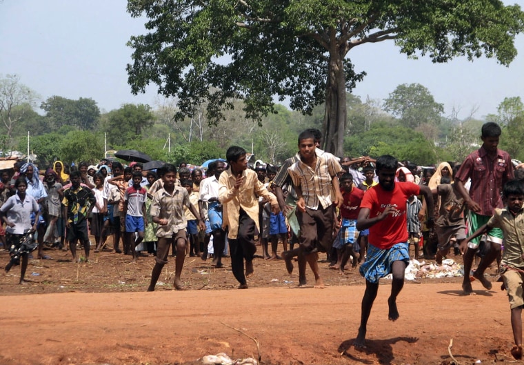 Sri Lankan ethnic Tamils run to reach a food distribution truck at a camp for the internally displaced at Manik Farm, in Vavuniya, Sri Lanka, Tuesday, April 28, 2009. (AP Photo)