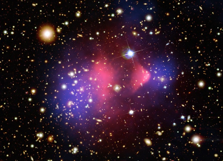 August 21, 2006: Dark matter and normal matter have been wrenched apart by the tremendous collision of two large clusters of galaxies. This composite image shows the galaxy cluster 1E 0657-56, also known as the \"bullet cluster.\" The hot gas detected by Chandra in X-rays is seen as two pink clumps in the image and contains most of the \"normal\" matter in the two clusters. The bullet-shaped clump on the right is the hot gas from one cluster, which passed through the hot gas from the other larger cluster during the collision. An optical image from Magellan and the Hubble Space Telescope shows the galaxies in orange and white. The blue areas in this image show where astronomers find most of the mass in the clusters.
