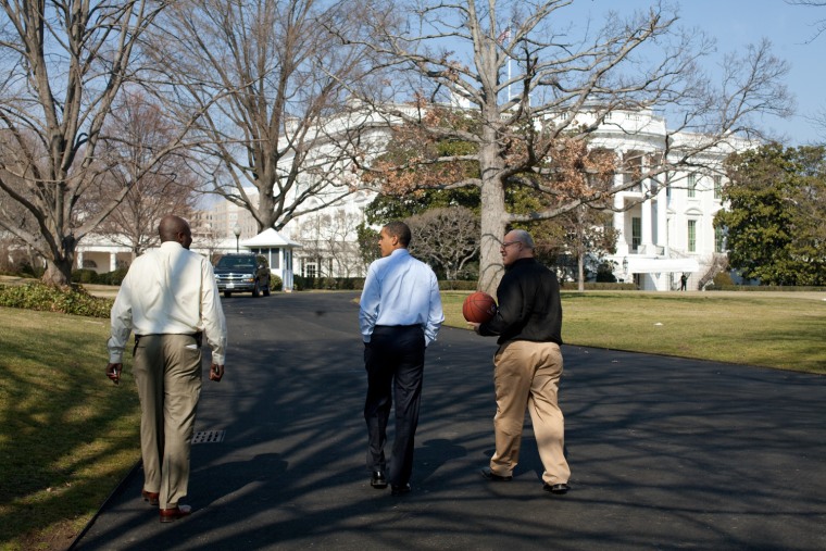 President Barack Obama walks towards the White House with friend Eric Whitaker, right and Personal Assistant Reggie Love after shooting hoops at the South Lawn basketball court. 3/6/09