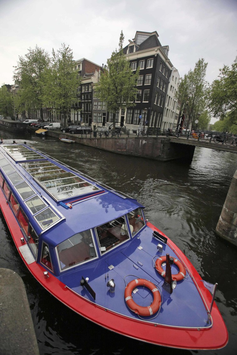 In this photo taken on April 17, 2009, a canal boat with tourists negotiates a lock near the harbor in Amsterdam, Netherlands. The inner city of the Dutch capital is a compact warren of heritage buildings, of museums both grand and odd, of hidden gardens and outdoor markets, all within easy reach by any mode of transport except the unwelcome car. No longer the bargain city of Europe, Amsterdam is still a city of wonders that can be had for a discount, and sometimes for free. (AP Photo/Peter Dejong)