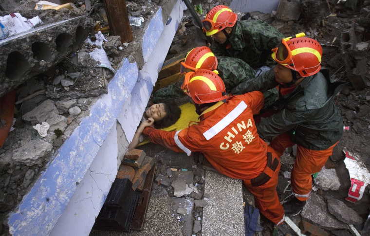Rescue workers pull out a young girl from under the rubble of a collapsed school in Juyuan, southwestern China's Sichuan province, Tuesday, May 13, 2008.  The death toll from a powerful earthquake in China that toppled buildings, schools and chemical plants climbed Tuesday to about 10,000, while untold numbers remained trapped after the country's worst quake in three decades. (AP Photo/Ng Han Guan)