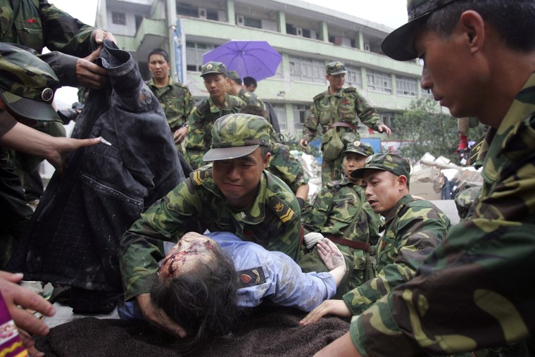 Image:Chinese rescuers carry a wounded person out of a collapsed building.