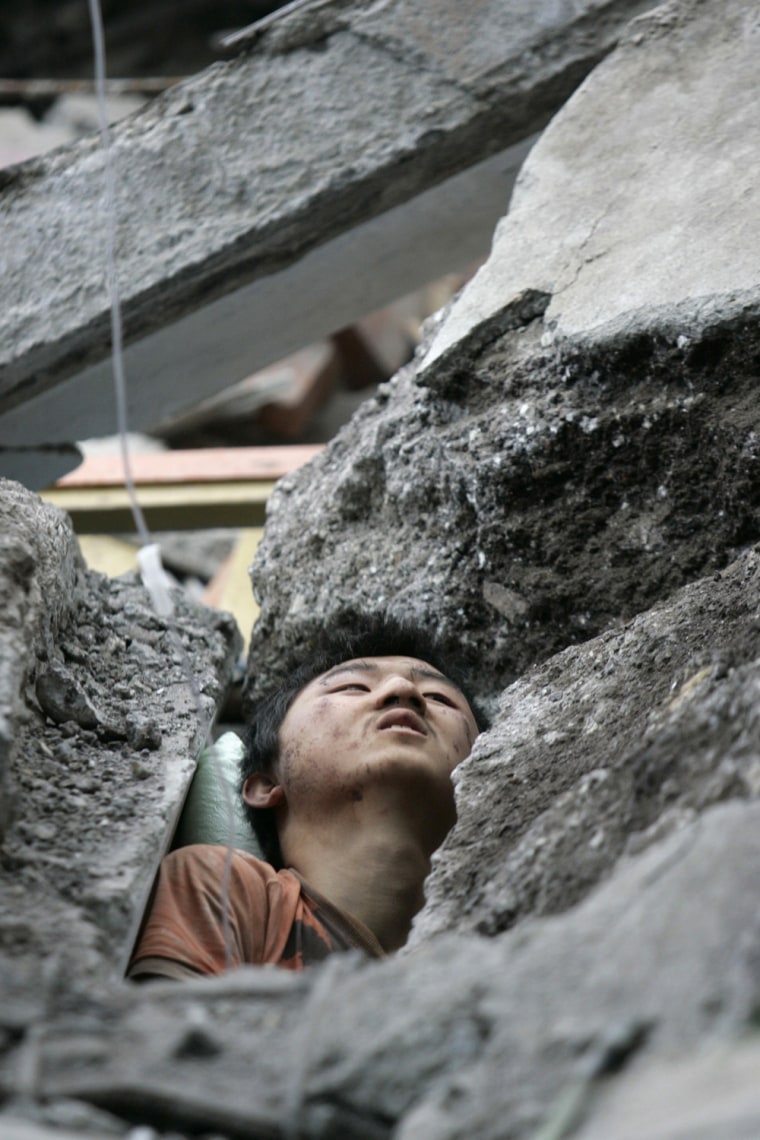 A survivor is seen among the rubble of a collapsed building at the earthquake-affected Beichuan County of Mianyang City