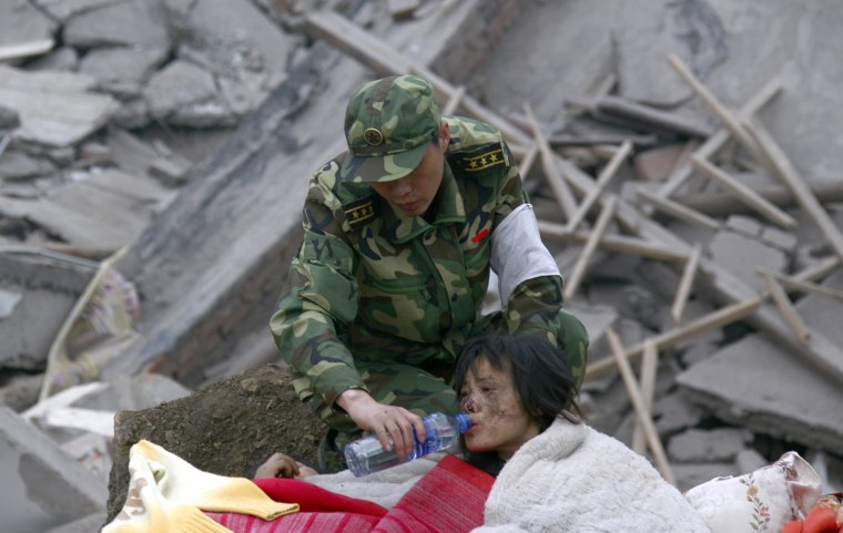 Image: A soldier gives a wounded woman water
