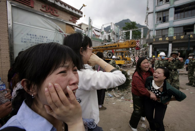 Parents cry in front of the rubble of a collapsed high school as they wait for news of their children at the earthquake-hit township of Hanwang