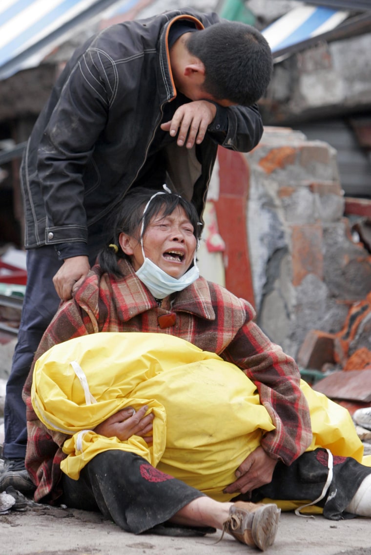 Parents mourn over their child who was killed in a collapsed school building in earthquake-hit Hongbai county of Shifang