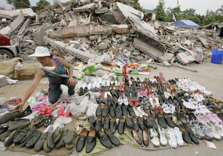 A woman sorts out shoes she dug out from the rubble as she waits for customers at Jiulong in the city of Mianzhu in China's Sichuan province on Wednesday May 28, 2008. A massive quake struck the country's southwest region on May 12. (AP Photo/Kyodo News) ** JAPAN OUT, MANDATORY CREDIT, FOR COMMERCIAL USE ONLY IN NORTH AMERICA **