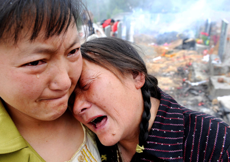 In this photo released by China's Xinhua News Agency, a mother and grandmother mourn for their child who died at a school in the May 12, 2008 earthquake,  at a cemetery in Qingchuan County, southwest China's Sichuan Province, Tuesday, May 12, 2009.  (AP Photo/Xinhua, Tao Ming) ** NO SALES **