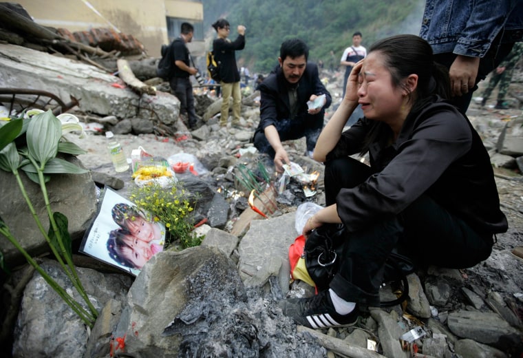 A mother cries while she mourns her dead daughter Xiang Yazi at the ruins of earthquake-hit Beichuan county
