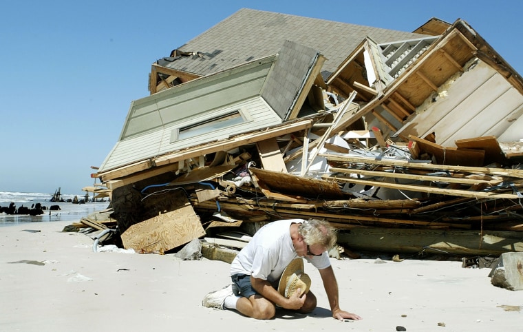 The owner of this house on Cape San Blas kneels to pray in front of the rubble, Friday, Sept. 17, 2004, in Cape San Blas, Fla.   The home was destroyed by the winds and waves of Hurricane Ivan as it passed through the area on Wednesday night.  When asked if he would rebuild in the same location, he stated that he was insured and would take the money and do good with it, whatever that might be. (AP Photo/Phil Coale)