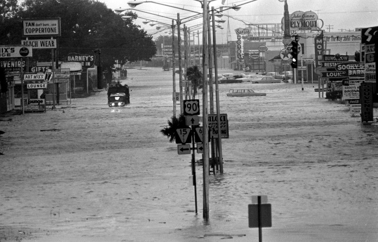 U.S. Highway 90 at Biloxi went under several feet of water as powerful Hurricane Betsy slammed into the mainland Sept. 10, 1965. At left in the background, a national guard truck makes its way through the water. (AP Photo)