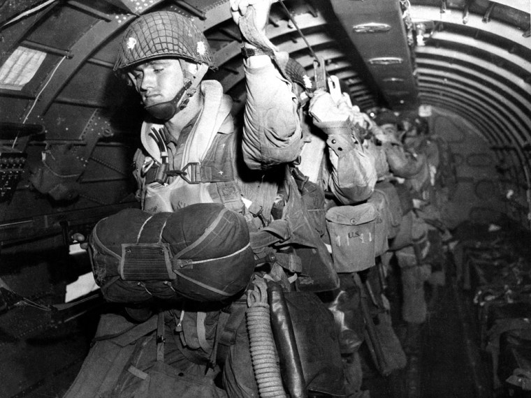 U.S. paratroopers fix their static lines before a jump  before dawn over Normandy on D-Day June 6, 1944, in France. The decision to launch the airborne attack in darkness instead of waiting for first light was probably one of the few Allied missteps on June 6, and there was much to criticize both in the training and equipment given to paratroopers and glider-borne troops of the 82nd and 101st airborne divisions. Improvements were called for after the invasion; the hard-won knowledge would be used to advantage later. (AP Photo/Army Signal Corps)