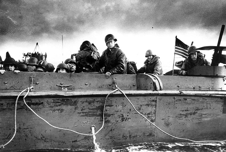 Troops and crewmen on a landing craft approaching a Normandy beach, June 6, 1944.