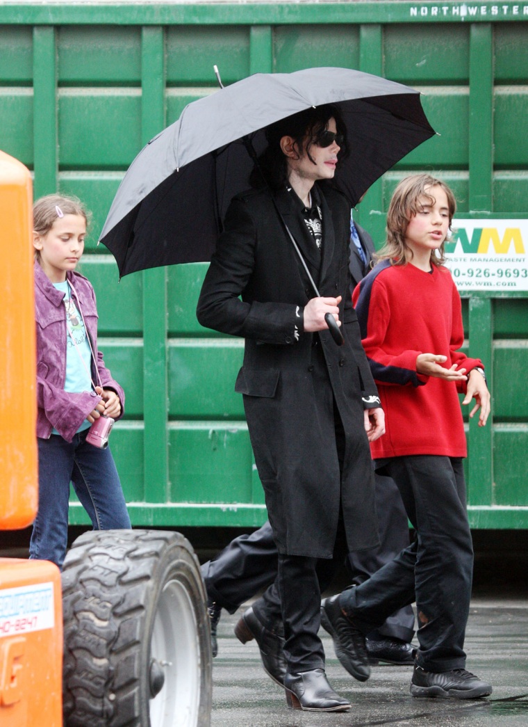 Michael Jackson walks with kids Prince and Paris through a studio parking lot in Los Angeles