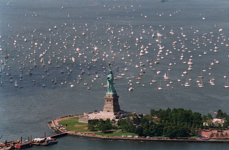 Small sailing ships and pleasure boats are moored near the Statue of Liberty in New York harbor, Thursday, July 3, 1986.  The vessels will leave the area during the Statue of Liberty rededication ceremonies.  (AP Photo/Mario Cabrera)