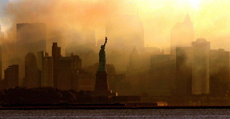 ** FOR USE AS DESIRED IN CONECTION WITH SEPT. 11 ANNIVERSARY--FILE **The Statue of Liberty is seen at first light, in this view from Jersey City, N.J., against a smoke-filled backdrop of the lower Manhattan skyline, in this Sept. 15, 2001 file photo. (AP Photo/Dan Loh, File)