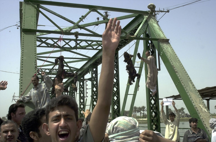 ** EDS NOTE GRAPHIC CONTENT ** Iraqis chant anti-American slogans as charred bodies hang from a bridge over the Euphrates River in Fallujah, west of Baghdad, Wednesday, March 31 2004. Enraged Iraqis in this hotbed of anti-Americanism killed four foreigners Wednesday, including at least one U.S. national, took the charred bodies from a burning SUV, dragged them through the streets, and hung them from the bridge. (AP Photo/Khalid Mohammed)