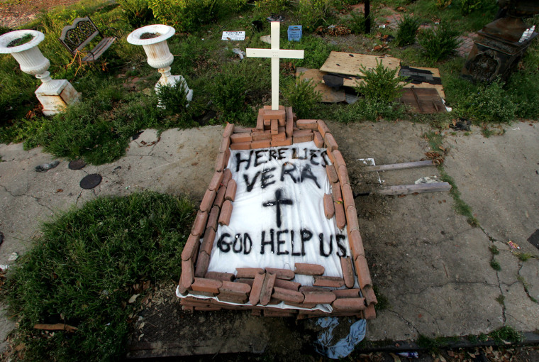 A makeshift tomb at a New Orleans street corner conceals a body that had been lying on the sidewalk for days in the wake of Hurricane Katrina on Sunday, Sept. 4, 2005.  The message reads, \"Here lies Vera. God Help Us.\" (AP Photo/Dave Martin)