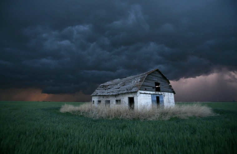 An old barn stands in a wheat field as a sever thunderstorm passes in the distance near Ogallah, Kan., Thursday, May 22, 2008. Severe thunderstorms dropped tornadoes across much of northwest Kansas. (AP Photo/Charlie Riedel)