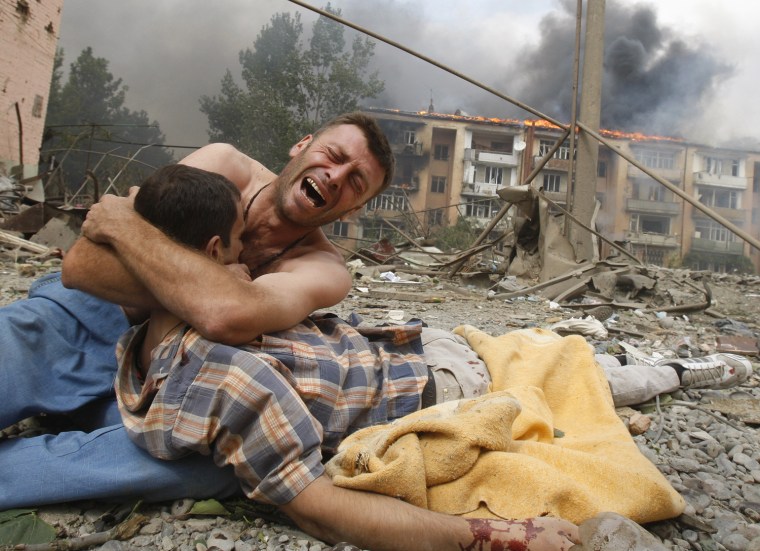 A Georgian man cries near the body of his relative after a bombardment  in Gori