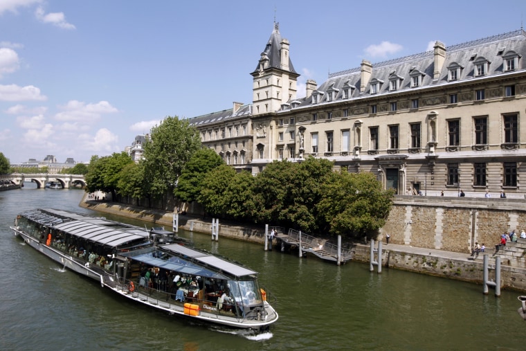 Image: A \"bateau mouche\" tourist boat travels near the Paris Justice court