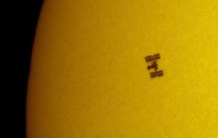 This photograph, taken with a camera attached to a special sun-observing telescope, shows the shuttle Endeavour and the international space station silhouetted by the sun during Endeavour's July mission.