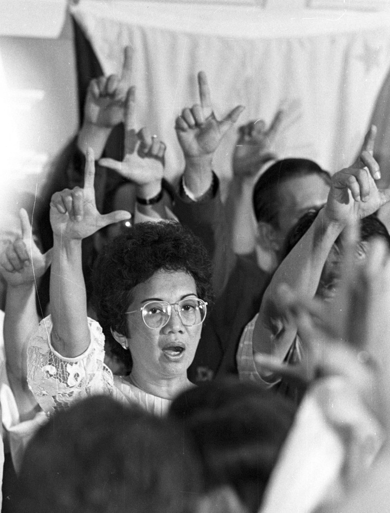 Image: File photo of Corazon Aquino showing Laban sign as she leads her followers in Bayan Ko