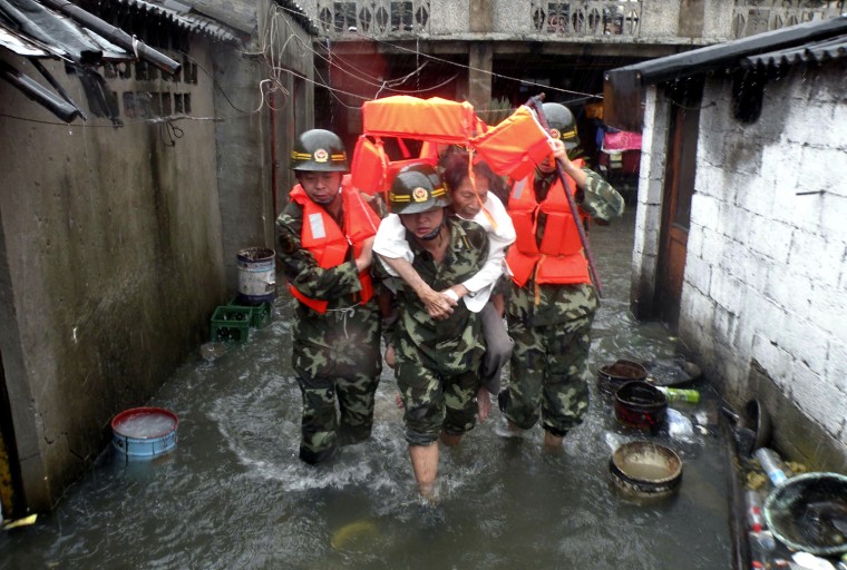 Image: Soldiers evacuate a stranded resident to a safe area as Typhoon Morakot hits Wenzhou