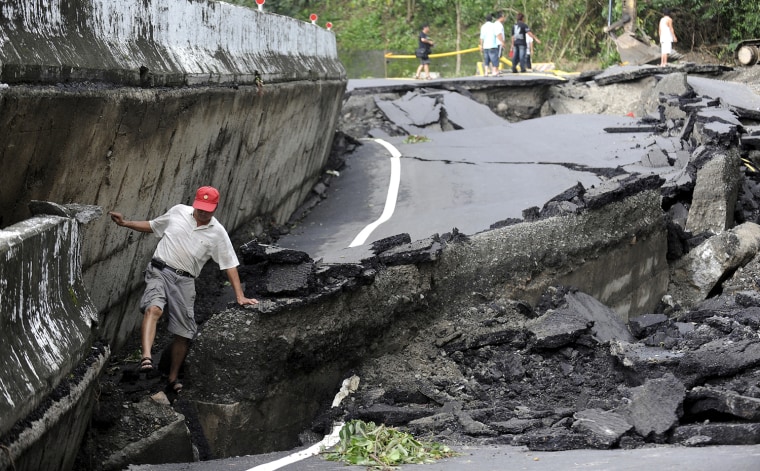Image: A man walks on a damaged road in Taiwan