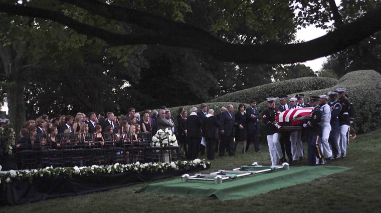 Image: The Kennedy family gathers around the grave site as an Honor Guard carries the casket of Sen. Ted Kennedy at Arlington National Cemetery, in Arlington, Va.