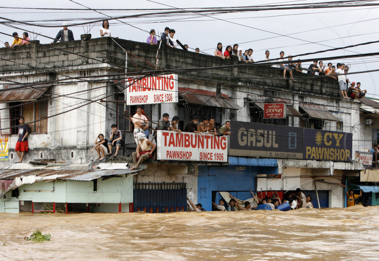 Image: Residents wait for rescuers at a building during flooding caused by Typhoon Ondoy in Cainta Rizal