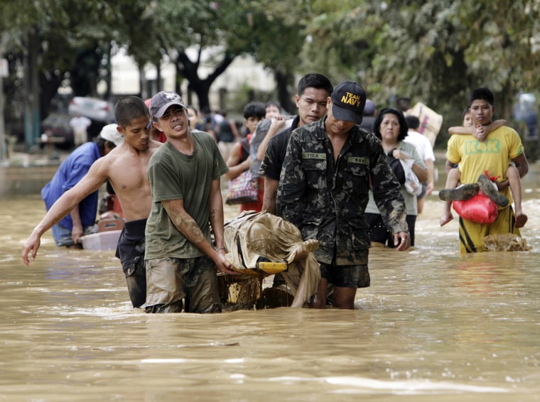 Image: Rescuers from Philippine Navy carry victim of flash floods caused by Typhoon Ondoy at Provident Village in Marikina City
