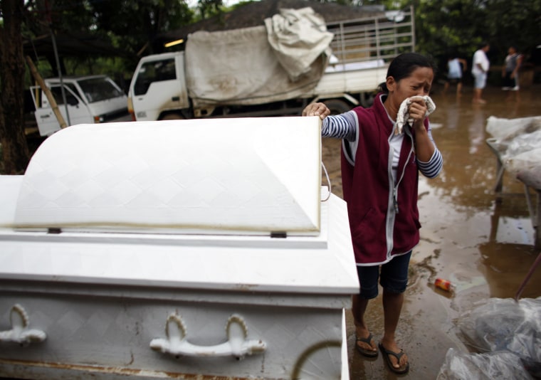 Image: A relative reacts after confirming the identity of a loved one killed from floods brought on by the continuous rains of Typhoon Ketsana in the town of Tanay, Rizal east of Manila
