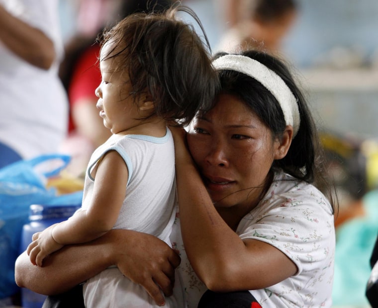Image: A Filipino victim of Typhoon Ketsana is seen crying with her child in an evacuation center