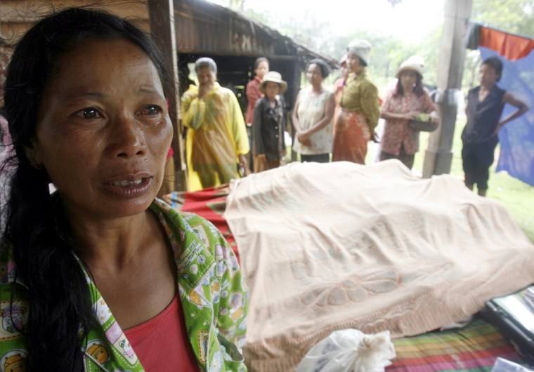 Image: A woman weeps near the bodies of people killed by Typhoon Ketsana at Sandane district in Kampong Thom province