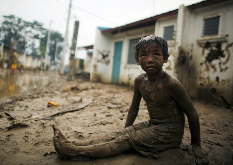 Image: A child sits on mud caused by Typhoon Ketsana in Montalban Rizal