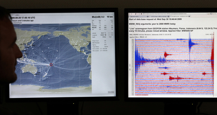 Image: A scientist shows a graph on a computer monitor registered during the earthquake in the Pacific off the Samoa islands region as he poses for the media in Potsdam
