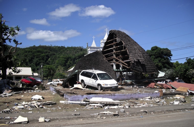 Image: A destroyed structure is seen among debris following a tsunami in the village of Leone
