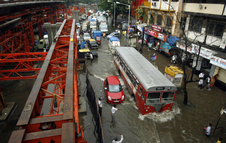 Image: Traffic moves through flooded streets in India