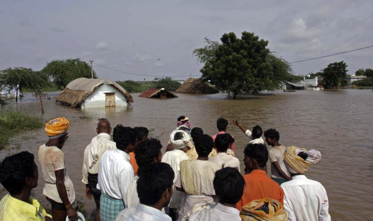 Image: Villagers look at their submerged homes in India