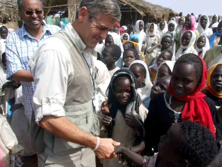 In this photo released by the United Nations and African Mission in Darfur (UNAMID), actor George Clooney, center, who has been designated as U.N. messenger of peace by U.N. Secretary General Ban Ki-Moon, visits the Zamzam refugee camp in North Darfur, Sudan, in late January 2008. (AP Photo/UNAMID,Sherren Zorba )