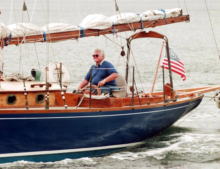 Senator Ted Kennedy sits at the helm of his sailbo