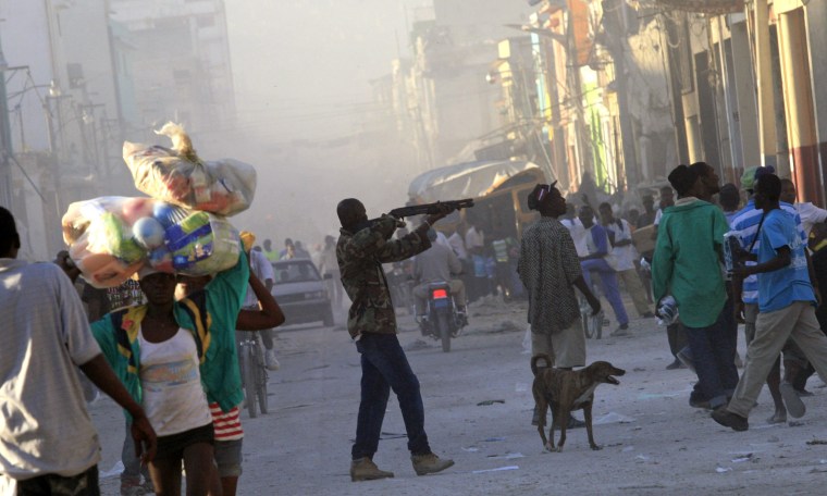 Image: A man points a gun to the crowd in downtown Port-au-Prince
