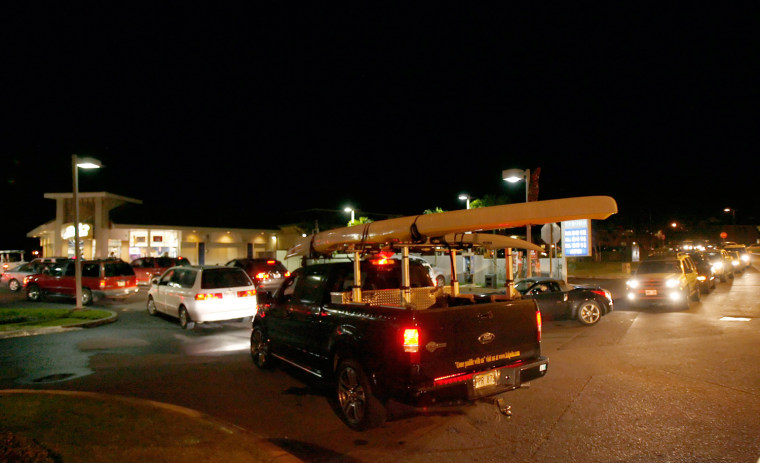 Image: A long line of cars wait to gas up after learning about the tsunami warning for the Hawaiian Islands in Mililani