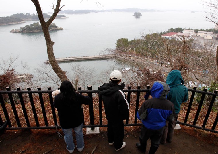 Image: Local residents watch Pacific coast as they evacuate during tsunami warning issued by the Japan Meteorological Agency at a shrine in Shichigahama