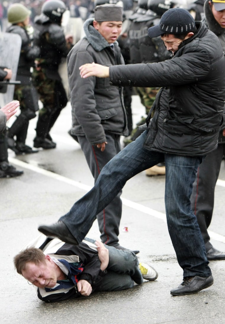 Image: A plain clothes policeman kicks an anti-government protester in Bishkek