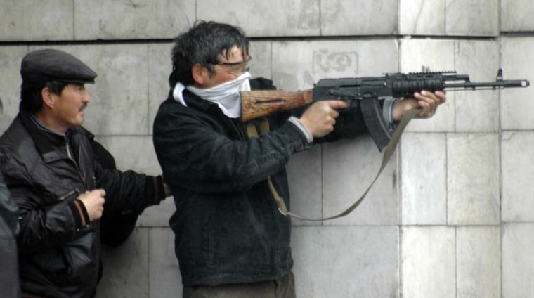 Image: An unidenttified man fires an automatic weapon near the main government building in Bishkek, Kyrgyzstan