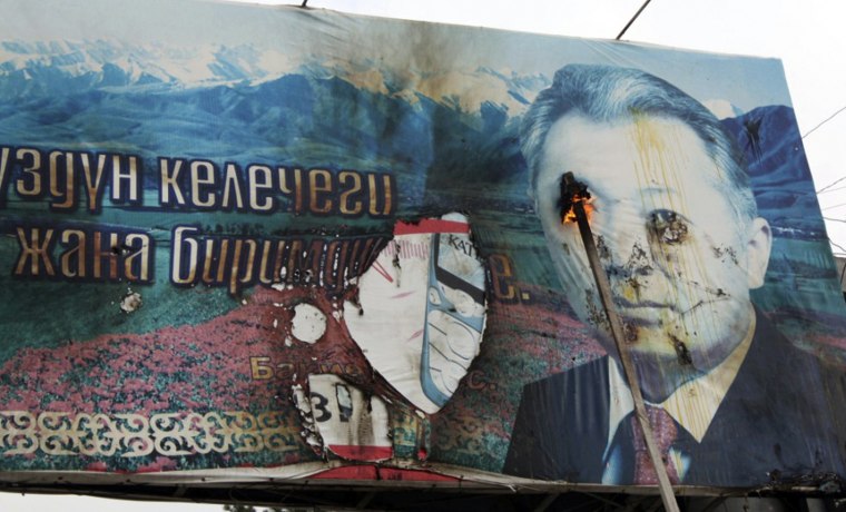 Image: Opposition supporters burn a billboard displaying Kyrgyz President Kurmanbek Bakiyev during a rally in the northwestern town of Talas